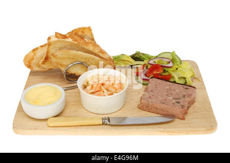 Pate ferme avec salade et toast rustique sur une planche en bois isolés contre white Banque D'Images