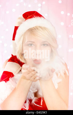 Jeune femme en costume père noël flocons de soufflage Banque D'Images