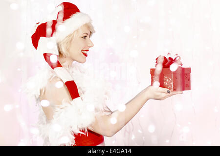 Jeune femme en costume père noël holding gift box Banque D'Images