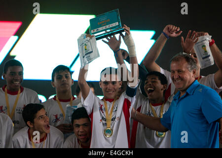 (140710) -- RIO DE JANEIRO, 10 juillet 2014 (Xinhua) -- Les joueurs de la Rocinha neighborhood bravo pour leur victoire avec légende du Brésil Zico joueur (1e R, à l'avant) dans la cérémonie du trophée après avoir battu les Vidigal quartier dans le match final de la Coupe du social à la Marina da Gloria, à Rio de Janeiro, Brésil, le 10 juillet 2014. Le Cup est organisée par Zico 10 projet, lancé par Zico, légende du Brésil de football, en partenariat avec la municipalité et les autorités de l'État. C'est un tournoi où huit équipes d'enfants à l'âge de 15 ans ou moins, qui représentent leurs communautés pauvres Banque D'Images