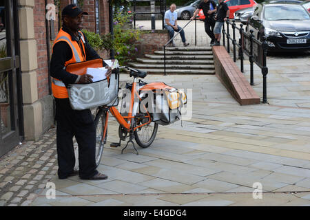 Un postier TNT offre mail à une adresse dans le centre-ville de Manchester, Banque D'Images