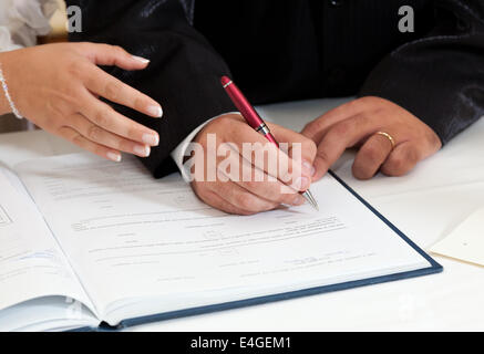 Mariée et le marié de la signature du certificat de mariage dans l'église Banque D'Images