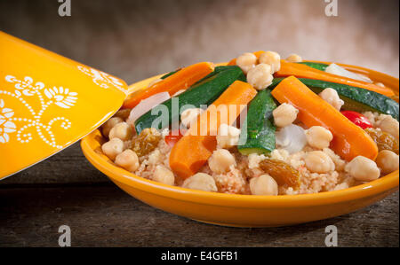 Tajine de légumes à couscous sur table en bois. Banque D'Images