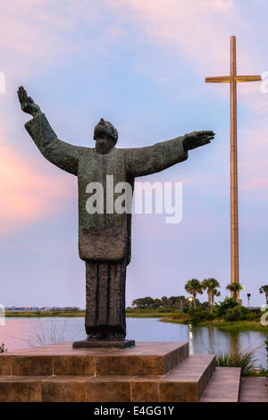 De magnifiques roses et bleus entourent Père Francisco López de Mendoza Grajales statue au coucher du soleil à la Mission Nombre de Dios. Banque D'Images