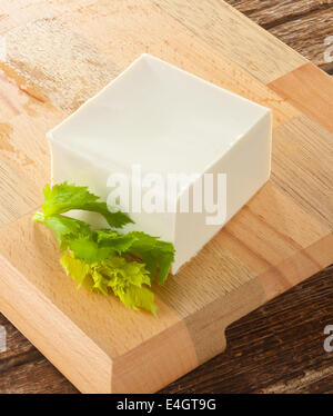 Cube de tofu frais sur la planche à découper en bois. Banque D'Images