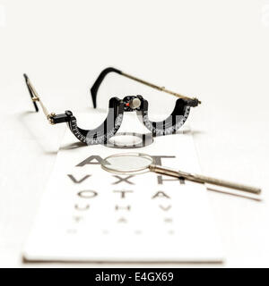 Un demi-châssis d'essai Oculus et traversé le cylindre croisé cross cyl sur un diagramme de Snellen avec une faible profondeur de champ - flou. Banque D'Images