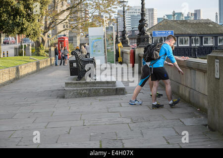 Les coureurs du jogging stretch bas chaud, sur une maison du travail sur un soir de printemps, Tamise, Lambeth, London UK Banque D'Images