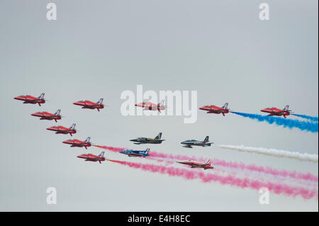 RAF Fairford, Gloucestershire UK. 11 juillet 2014. Des flèches rouges jets Hawk de la RAF AEROBATIC TEAM 50e saison d'affichage pour saluer le survol de la formation avec les dirigeants de la Patrouille de France, les Frecce Tricolori, la Patrouille Suisse Breitling Jet Team et le premier jour de riat. Credit : Malcolm Park editorial/Alamy Live News Banque D'Images
