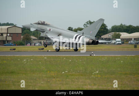 RAF Fairford, Gloucestershire UK. 11 juillet 2014. L'Eurofighter Typhoon RGF4 de RAF Coningsby complet avec bandes d'invasion jour arrive pour un affichage au premier jour de riat. L'état de l'art jet spécialement peint avec la célèbre marques noires et blanches en hommage au rôle de l'équipage du Hawker Typhoon au cours de la D-day operations. Credit : Malcolm Park editorial/Alamy Live News Banque D'Images