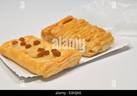 Deux morceaux de tarte aux raisins secs sur plaque avec papier sac papier, Close up, isolé sur fond blanc Banque D'Images