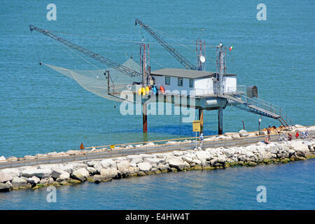 Gros plan du rare fishermens hut sur pilotis avec grande suspendue net & l'accès depuis le chemin le long du brise-lames du port public Banque D'Images