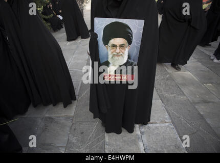 Téhéran, Iran. 12 juillet, 2014. 12 juillet 2014 - Téhéran, Iran - l'Iran une femme voilée est titulaire d'un placard avec un portrait de l'Iran l'Ayatollah Ali Khamenei comme elle prendre part à un rassemblement à l'appui de l'hijab (vinaigrette) Code islamique dans le parc Mellat (Nation) dans le nord de Téhéran. Morteza Nikoubazl/ZUMAPRESS : Morteza Nikoubazl Crédit/ZUMA/Alamy Fil Live News Banque D'Images