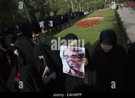 Téhéran, Iran. 12 juillet, 2014. 12 juillet 2014 - Téhéran, Iran - l'Iran une femme voilée est titulaire d'un placard avec un portrait de l'imam Ali, tué iranien KHALILI, qui est connu comme le martyr de Nahi Anil Munkar, pendant un rassemblement à l'appui de l'hijab (vinaigrette) Code islamique dans le parc Mellat (Nation) dans le nord de Téhéran. Morteza Nikoubazl/ZUMAPRESS : Morteza Nikoubazl Crédit/ZUMA/Alamy Fil Live News Banque D'Images