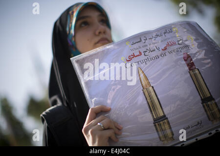 Téhéran, Iran. 12 juillet, 2014. Une femme iranienne voilée regarde elle tenir un placard alors qu'il participait à une manifestation en soutien du hijab (code vestimentaire islamique) dans le parc Mellat, dans le nord de Téhéran. © Morteza Nikoubazl/ZUMA/Alamy Fil Live News Banque D'Images