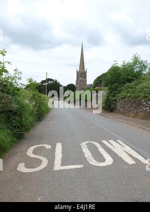 Peint signe lent sur la route sur les approches à Winterbourne Église dans la Loire. Juin 2014 Banque D'Images