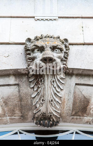 Autocollant sur une porte d'un lion de pierre sculpté son visage, avec une longue langue. Banque D'Images