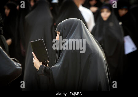 Téhéran, Iran. 12 juillet, 2014. Une femme iranienne prend des photos au cours d'une protestation contre les femmes qui violent le strict code vestimentaire islamique à Téhéran, Iran, le 12 juillet 2014. Le Hijab, une couverture des cheveux et le corps pour les femmes, a été tenu en public après la révolution islamique en Iran en 1979. Credit : Ahmad Halabisaz/Xinhua/Alamy Live News Banque D'Images