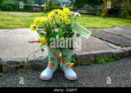 Pays de Galles, Royaume-Uni, de Beddgelert : gumboots décorées ornent le cimetière de l'église de Sainte Marie au cours de l'année festival de fleurs. Banque D'Images