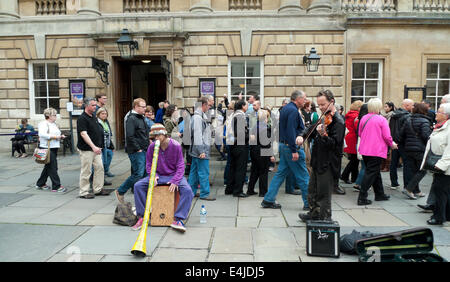 Les touristes à regarder les artistes interprètes ou exécutants dans la cour à l'extérieur des bains romains à l'abbaye de Bath, Somerset, Angleterre Royaume-uni KATHY DEWITT Banque D'Images