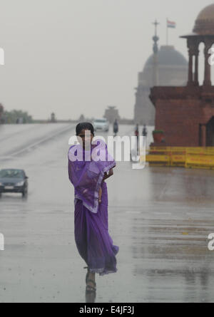New Delhi, Inde. Le 13 juillet, 2014. Une femme portant son enfant marche dans la pluie qui refroidit le temps à New Delhi, Inde, le 13 juillet 2014. Credit : Partha Sarkar/Xinhua/Alamy Live News Banque D'Images