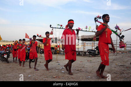 Allahabad, Inde. Le 13 juillet, 2014. Les dévots connu comme Kanwariya effectuée à partir de l'eau bénite le Gange près de la ville indienne du nord d'Allahabad. Kanwarias sont des fervents d'effectuer un pèlerinage rituel dans lequel ils marchent les routes de l'Inde, vêtus de safran, et de transporter des bidons richement décoré d'eau sacrée du Gange sur les épaules de la rapporter à des temples hindous dans leur ville, au cours de l'Hindu mois lunaire de Shravana. Credit : Prabhat Kumar Verma/Pacific Press/Alamy Live News Banque D'Images