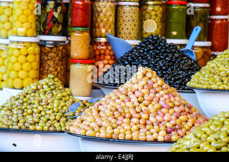 Éventail coloré de bols de assortiment olives et pickles en pots sur l'affichage à un marché de producteurs ou country store Banque D'Images