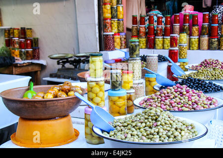 Éventail coloré de bols de assortiment olives et pickles en pots sur l'affichage à un marché de producteurs ou country store Banque D'Images