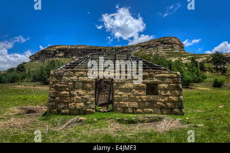 Maison construite par la moitié dans le paysage vallonné de la région du Lesotho Thaba-tseka. Le Lesotho, officiellement le Royaume du Lesotho, est un l Banque D'Images