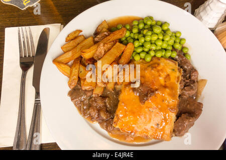 Pub Anglais traditionnel repas steak pie de pois et de croustilles de pommes de terre et de la sauce Banque D'Images