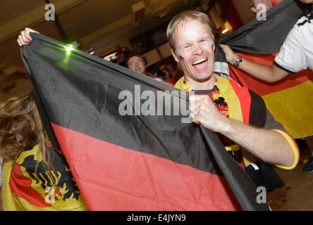 Vancouver, Canada, le 13 juillet, 2014. Un supporter allemand vagues un drapeau pour célébrer l'Allemagne a gagné la Coupe du Monde en Allemagne Alpen Club de Vancouver, Canada, le 13 juillet 2014. Environ 500 supporters de football Allemagne se rassemblent à une Allemagne club de Vancouver pour une émission en direct jeu et célébrer après que l'Allemagne a remporté le champion de la Coupe du monde au cours de la dernier match avec l'Argentine par 1-0. (Xinhua/Liang Sen) Credit : Xinhua/Alamy Live News Banque D'Images