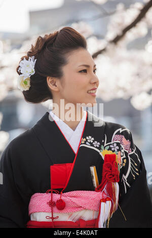 Jeune femme en kimono de mariage traditionnel au milieu de fleurs de cerisier dans le quartier Higashi Chaya de Kanazawa Banque D'Images