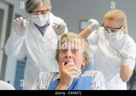 Peur teenage boy patient à une clinique dentaire dentiste assistant effrayant Banque D'Images