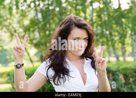 Belle jeune fille sur la nature montre un signe que tout va bien Banque D'Images