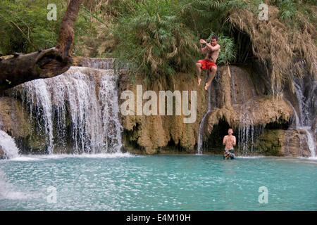 Les touristes à Kuang Si se balançant au dessus d'une piscine extérieure et de calcaire, près de Luang Prabang, Laos. Banque D'Images