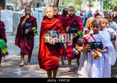 Les jeunes moines et nonnes bouddhistes à attendre en ligne pour l'alimentation lors d'une cérémonie à l'alms Maha Aung Mye Bonzan Monastery à Mandalay, Myanmar. Banque D'Images