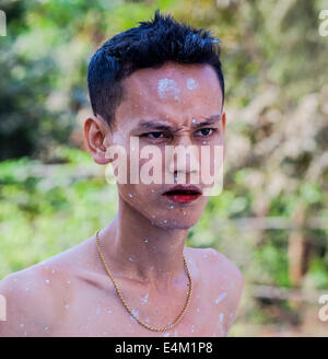 Les jeunes travailleurs de cette pagode bouddhiste/temple à Mandalay, Myanmar mélanger la peinture à la main, puis mettre une couche sur un stupa. Banque D'Images