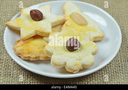 Quatre biscuits de Noël aux amandes et noisettes sur plaque blanche, Close up sur toile Banque D'Images