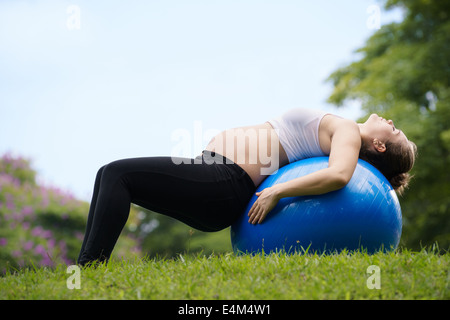 Portrait de femme enceinte belle blanche faisant de l'exercice de remise en forme dans le parc de l'abs sur fitness ball. Copy space Banque D'Images
