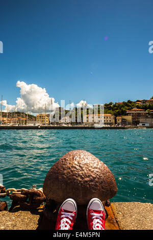 Reposant sur la jetée d'un petit port en Italie Banque D'Images