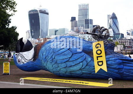 Londres, Royaume-Uni. 14 juillet 2014. Une fibre de verre géant perroquet mort près de 50 pieds de long a été mis sur le dos au champ du potier près de London Bridge, Londres pour promouvoir les Monty Python en direct sur la chaîne TV de l'or. C'est une réplique de la mythique Norwegian Blue qui fait l'objet d'une des plus célèbres sketches Monty Python. Crédit : Paul Brown/Alamy Live News Banque D'Images