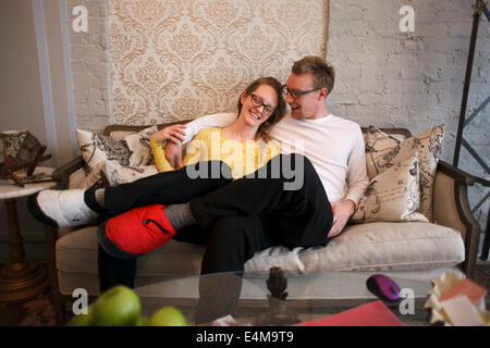 Laughing Couple Sitting on Couch Banque D'Images