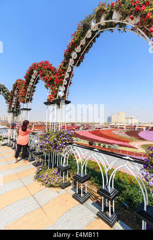 Photographies Visiteur femme couverte de fleurs de la vallée à la Dubai's Miracle jardin, plus grand jardin de fleurs naturelles dans le monde Banque D'Images