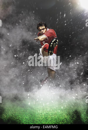 Soccer Player Kicking En Mid-Air Banque D'Images