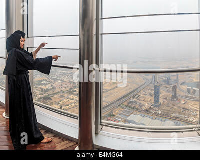 Les femmes portant la burka musulmane traditionnelle robes voir la ville de Dubai à partir du haut de la Burj Khalifa Banque D'Images