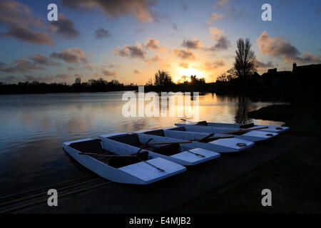 Coucher de soleil sur la barques en bois coloré à la location sur le simple à Aldeburgh village, comté de Suffolk, Angleterre Banque D'Images