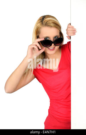 Woman peering sur lunettes surdimensionnées Banque D'Images
