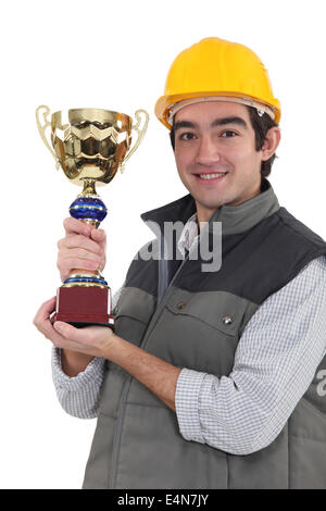 Builder holding trophy Banque D'Images