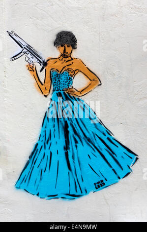 Graffiti par d'interminables dans Puma, Shoreditch, montrant femme en robe longue avec des armes à feu. Banque D'Images