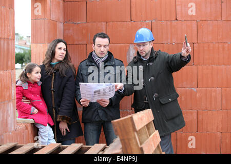 Famille étant illustré autour de construction site Banque D'Images