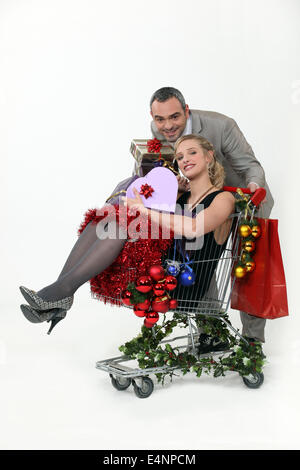 Couple avec chariot plein de cadeaux de Noël Banque D'Images